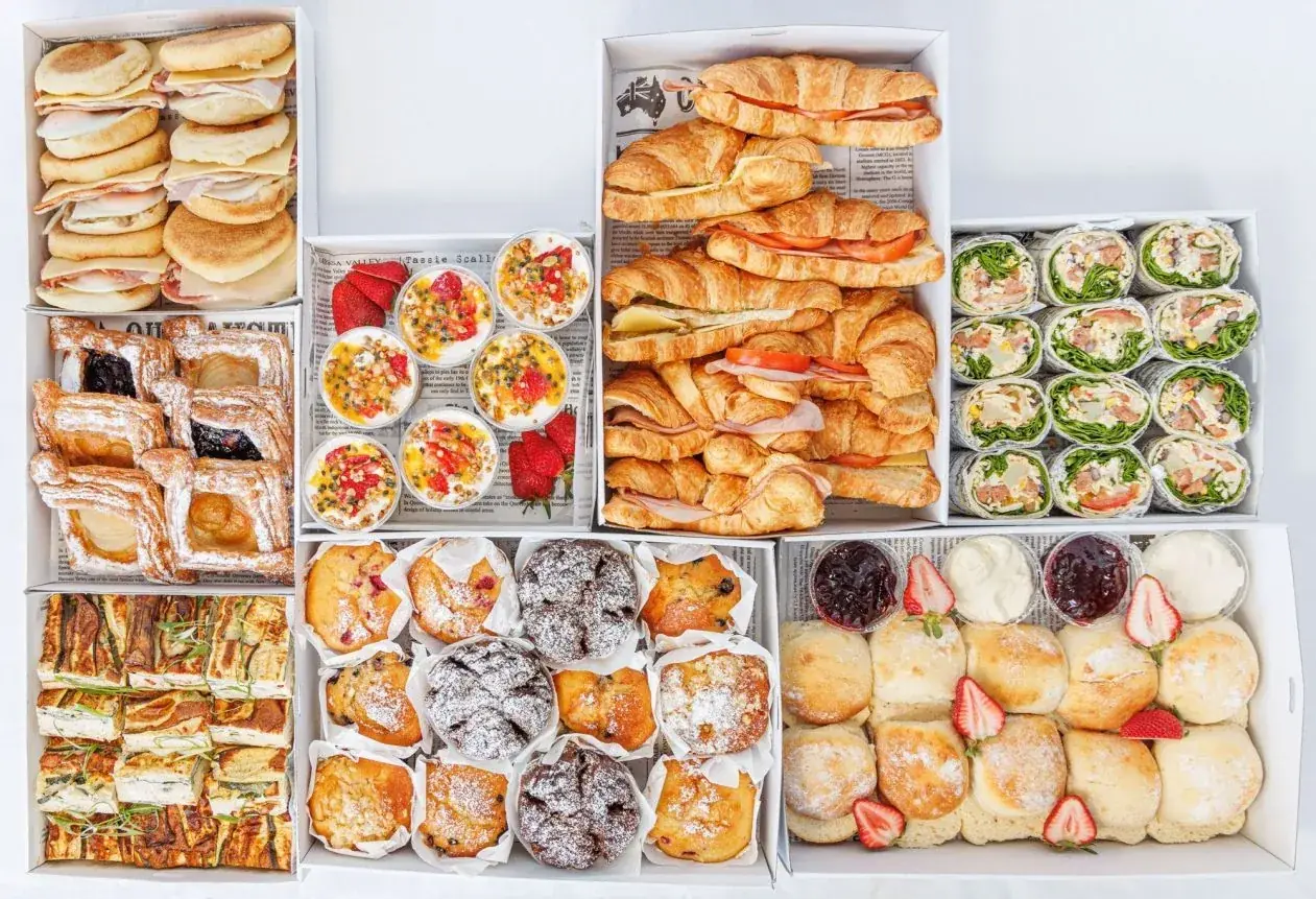 Breakfast catering boxes with croissants, danishes, muffins and fresh fruit