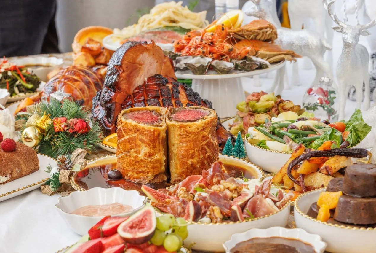Christmas catering spread with roast turkey, breads, salads, seafood and dessert