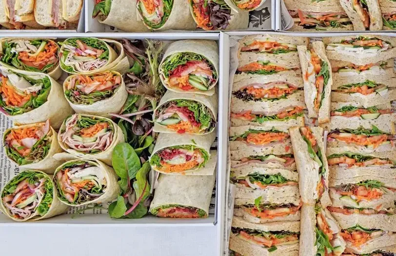 Filled baguettes and long rolls cut and boxed for a Cairns office catering delivery